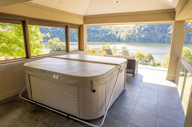 view of patio / terrace with a water view and a hot tub