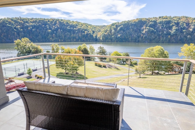 balcony with an outdoor living space and a water view