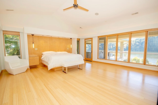 bedroom featuring light wood-type flooring, vaulted ceiling, and multiple windows