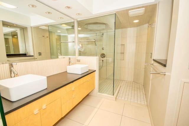 bathroom with tile floors, a shower with door, and dual vanity