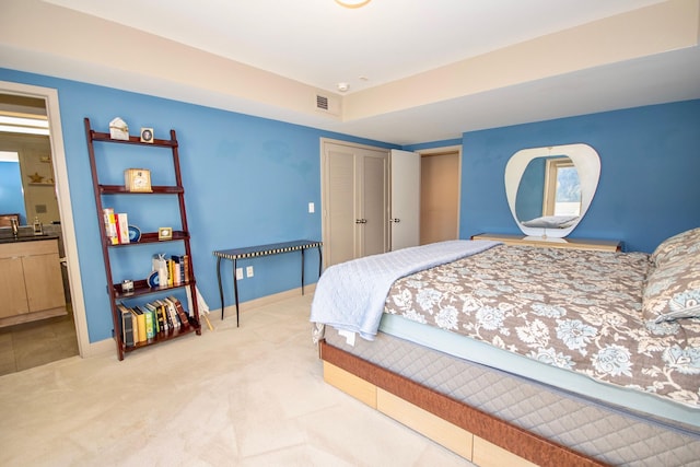 carpeted bedroom with a closet and sink