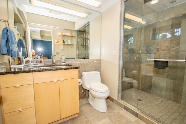 bathroom featuring vanity, tile walls, a shower with door, tile flooring, and toilet