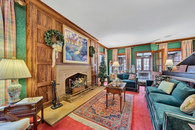 carpeted living room with ceiling fan and ornamental molding