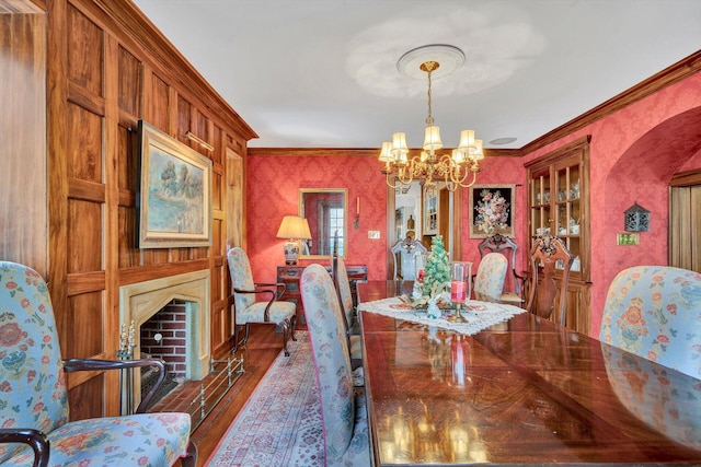 dining space with a notable chandelier, crown molding, and dark hardwood / wood-style floors