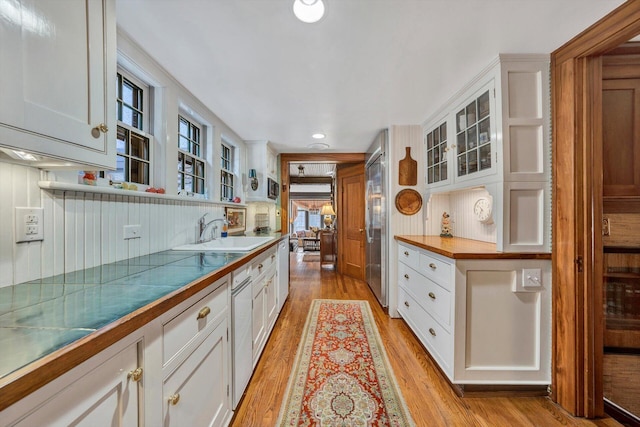 kitchen with high quality fridge, white cabinets, sink, and light wood-type flooring