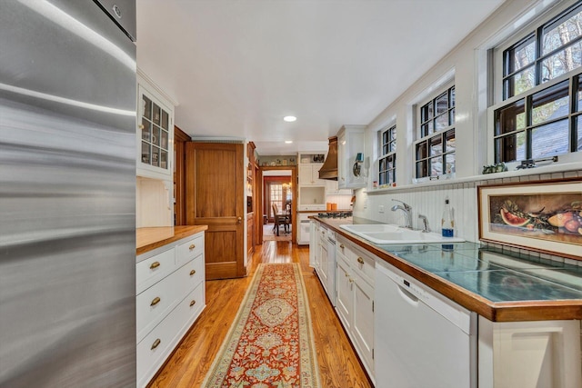 kitchen with white cabinets, light hardwood / wood-style floors, and dishwasher