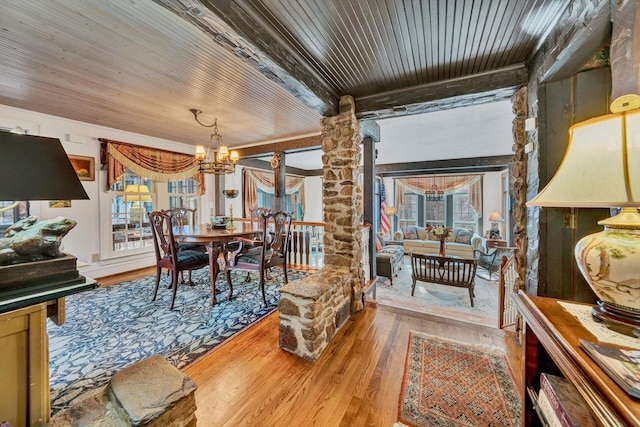 interior space featuring decorative columns, wood ceiling, a chandelier, and light wood-type flooring