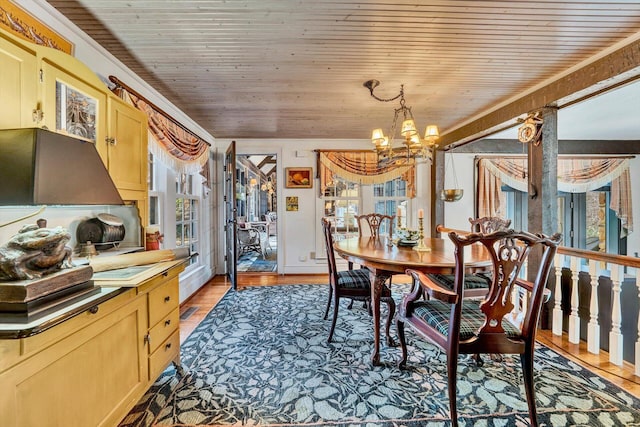 dining room featuring wooden ceiling, light wood-type flooring, a chandelier, and a healthy amount of sunlight