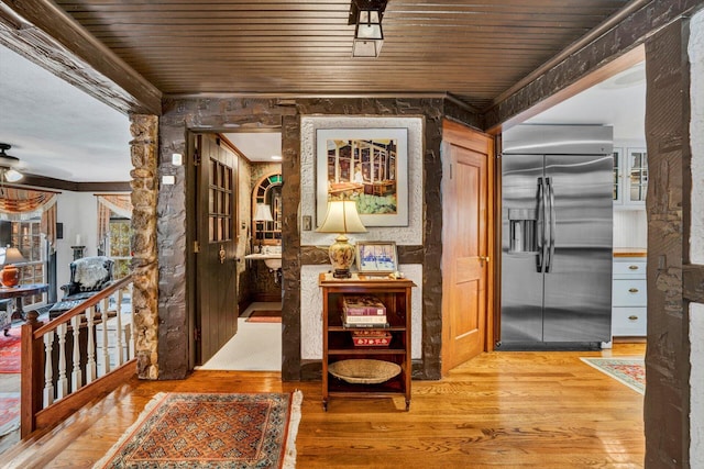 interior space with wood ceiling, crown molding, and light hardwood / wood-style floors