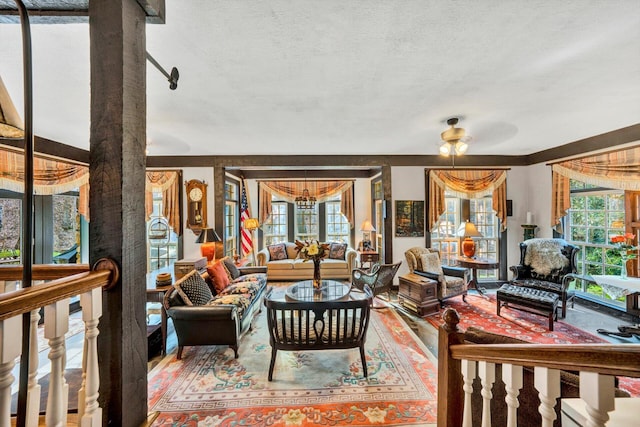 living room with hardwood / wood-style flooring, a healthy amount of sunlight, ceiling fan, and a textured ceiling