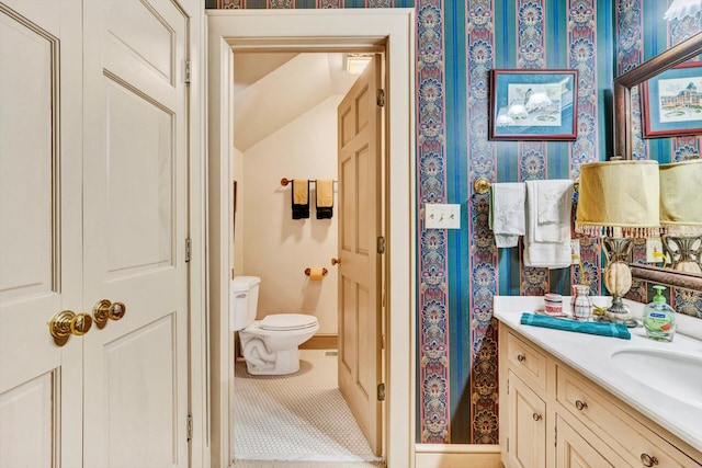 bathroom with toilet, tile floors, and vanity