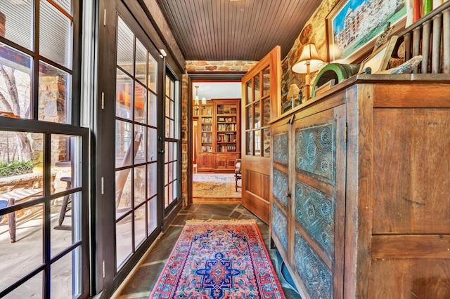 interior space featuring dark tile flooring, french doors, wood ceiling, and a notable chandelier