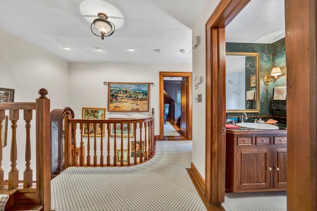 hallway with sink and light carpet