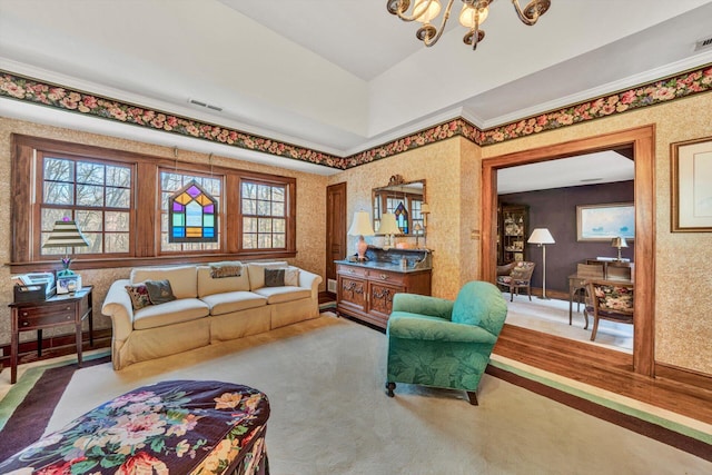 carpeted living room with ornamental molding and a chandelier