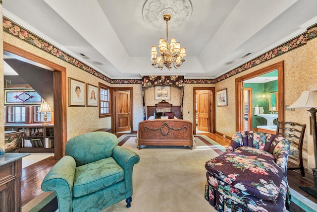 bedroom featuring a raised ceiling, light hardwood / wood-style floors, and a chandelier