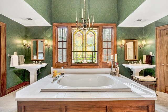 bathroom featuring an inviting chandelier and a bath