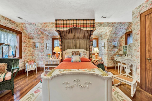 bedroom with hardwood / wood-style floors and a textured ceiling