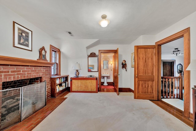 living area featuring a fireplace and dark colored carpet