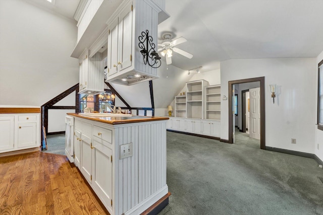 kitchen featuring sink, ceiling fan, light hardwood / wood-style flooring, vaulted ceiling, and white cabinetry