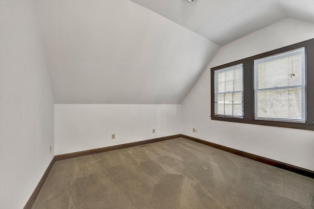 additional living space featuring lofted ceiling and carpet floors