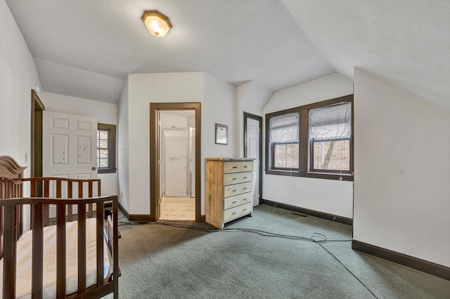 bonus room with lofted ceiling, a textured ceiling, and dark colored carpet