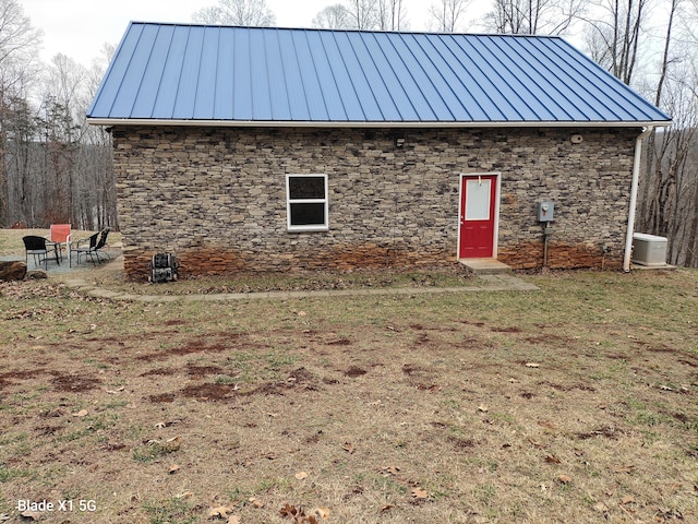 view of side of property featuring central AC unit and a yard