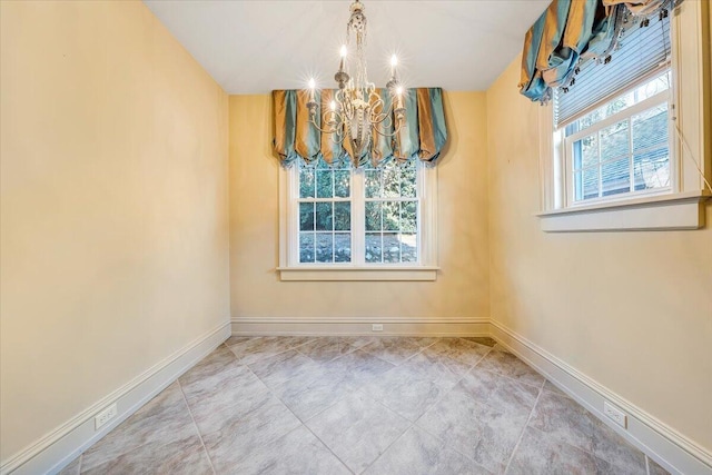 spare room featuring an inviting chandelier, plenty of natural light, and light tile floors