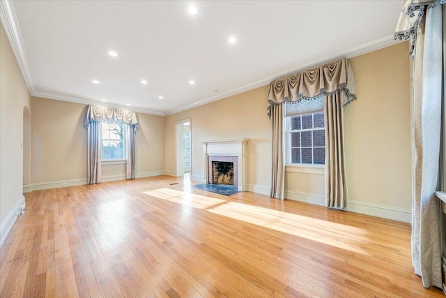 unfurnished living room with a brick fireplace, light hardwood / wood-style flooring, and crown molding