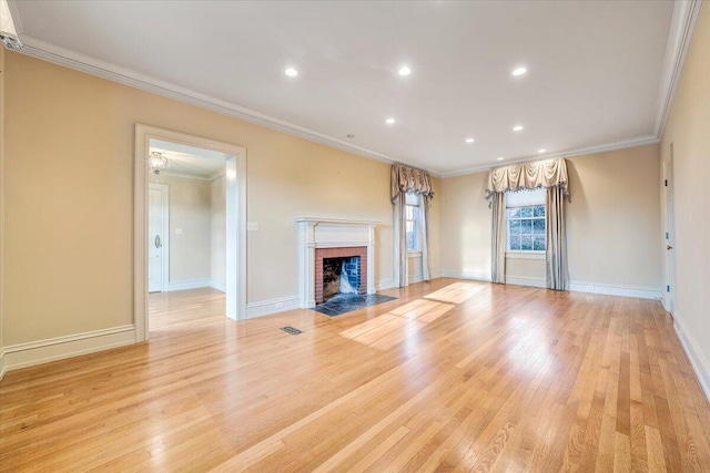 unfurnished living room with light hardwood / wood-style flooring, crown molding, and a brick fireplace