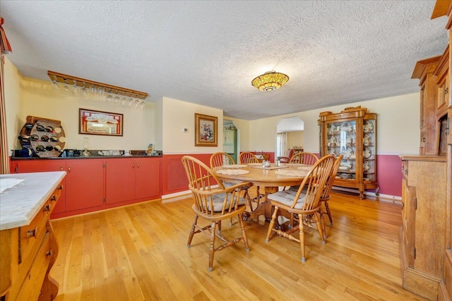 dining area featuring light hardwood / wood-style flooring and a textured ceiling