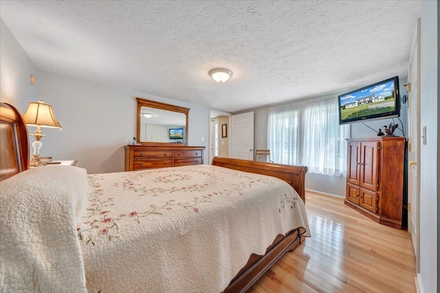 bedroom featuring light hardwood / wood-style floors and a textured ceiling