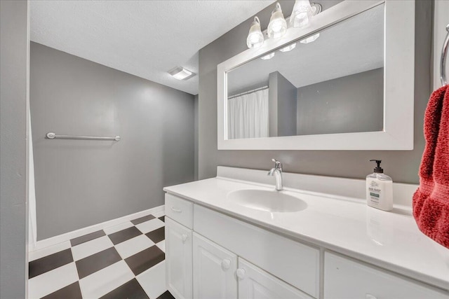 bathroom with vanity, a textured ceiling, and tile floors