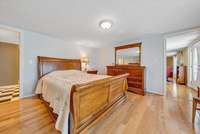 bedroom with light wood-type flooring and a textured ceiling