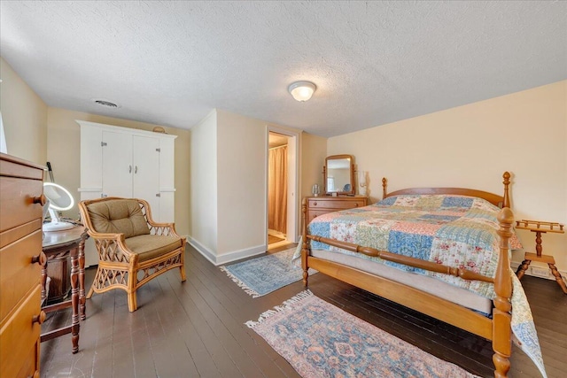 bedroom with a textured ceiling and dark hardwood / wood-style floors