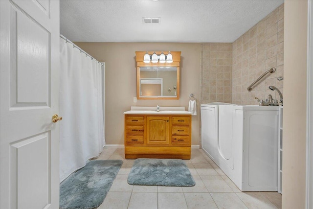 bathroom featuring tile flooring, oversized vanity, and a textured ceiling