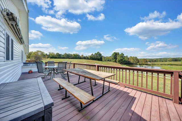 wooden terrace featuring a lawn and a water view