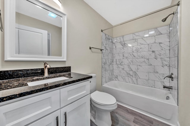 full bathroom with tiled shower / bath combo, toilet, wood-type flooring, and vanity