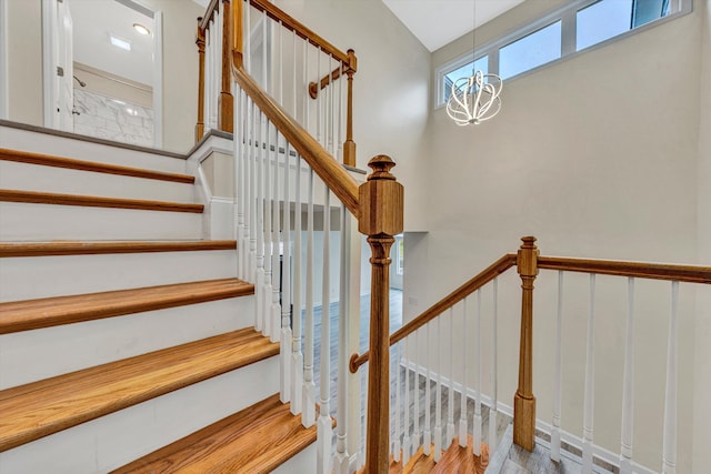 stairway featuring hardwood / wood-style flooring and a notable chandelier