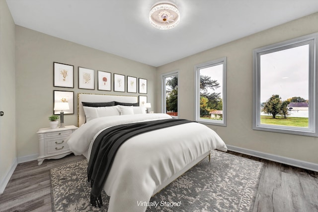 bedroom with dark hardwood / wood-style flooring