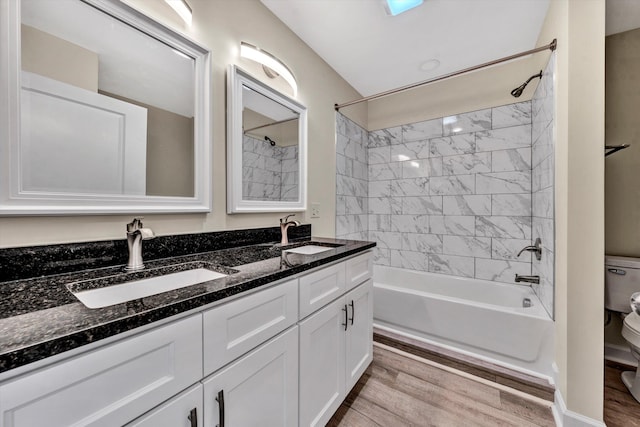 full bathroom featuring hardwood / wood-style flooring, toilet, vanity, and tiled shower / bath