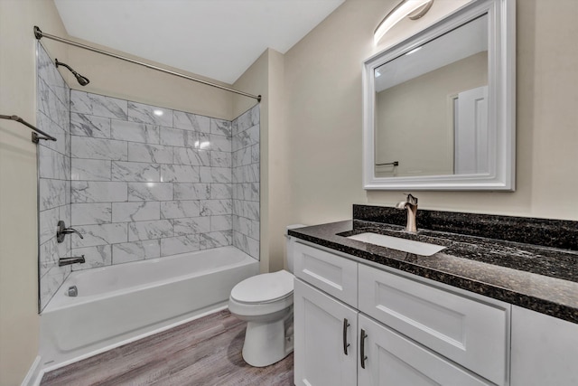 full bathroom featuring hardwood / wood-style flooring, vanity, toilet, and tiled shower / bath