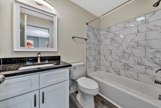 full bathroom with hardwood / wood-style floors, tiled shower / bath combo, toilet, and vanity