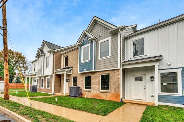 multi unit property featuring a front yard and central AC