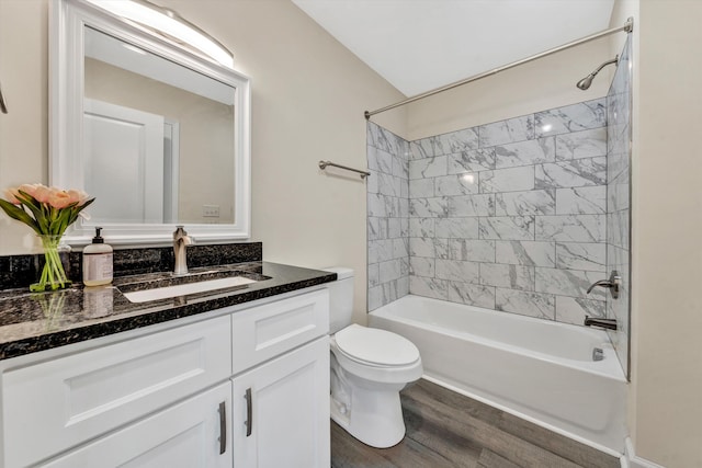 full bathroom featuring vanity, wood-type flooring, tiled shower / bath combo, and toilet