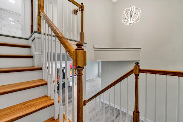 staircase with a notable chandelier