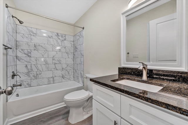 full bathroom with tiled shower / bath, toilet, vanity, and hardwood / wood-style flooring