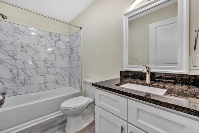 full bathroom with vanity, wood-type flooring, tiled shower / bath combo, and toilet