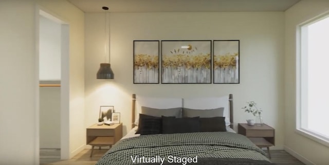 bedroom with multiple windows and wood-type flooring