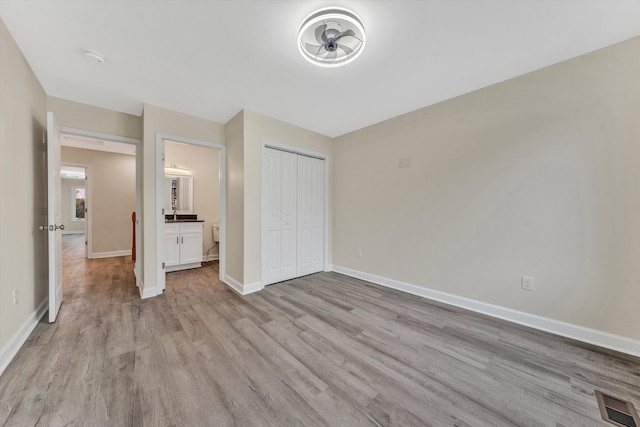 unfurnished bedroom with a closet and light hardwood / wood-style floors