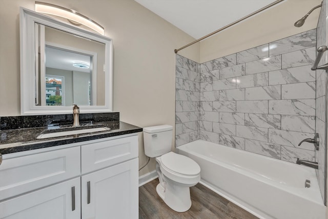 full bathroom with tiled shower / bath combo, toilet, wood-type flooring, and vanity